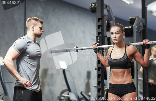 Image of man and woman with barbell flexing muscles in gym