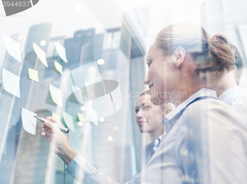 Image of smiling business people with marker and stickers