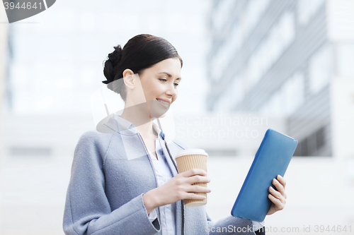 Image of smiling business woman with tablet pc in city