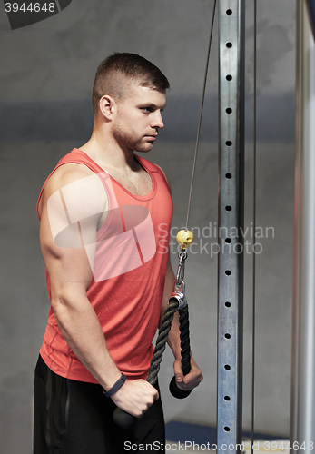 Image of man flexing muscles on cable machine gym