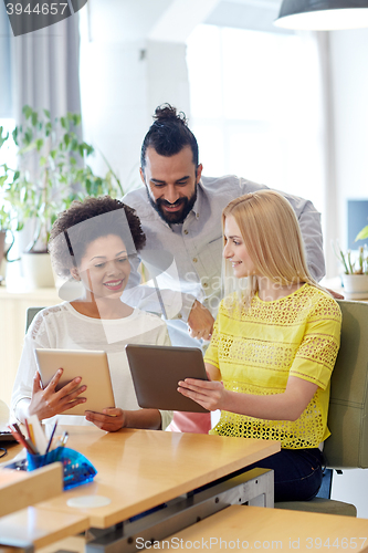 Image of happy creative team with tablet pc in office