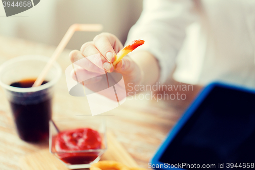 Image of close up of woman hand holding french fries