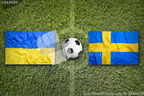 Image of Ukraine vs. Sweden flags on soccer field