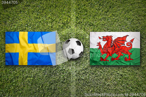 Image of Sweden vs. Wales flags on soccer field