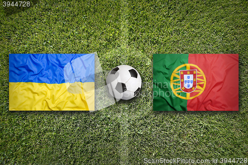 Image of Ukraine vs. Portugal flags on soccer field