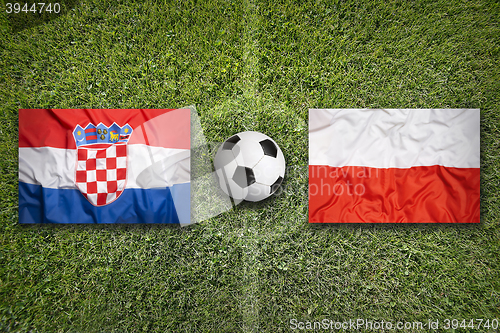 Image of Croatia vs. Poland flags on soccer field