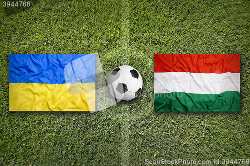 Image of Ukraine vs. Hungary flags on soccer field