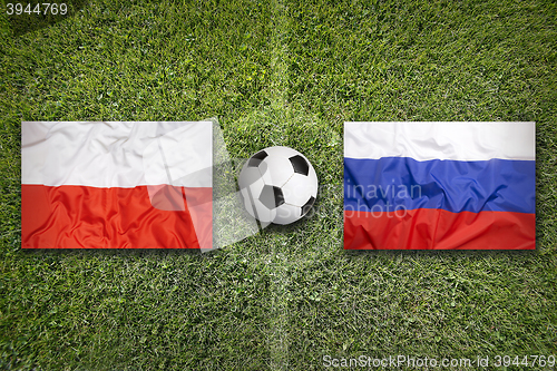 Image of Poland vs. Russia flags on soccer field