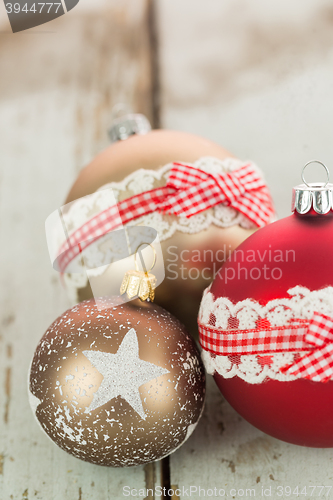 Image of Three Christmas baubles on rustic wood