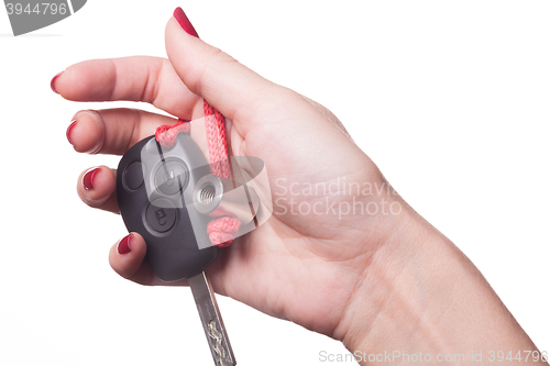 Image of Close up of hand holding car key on white