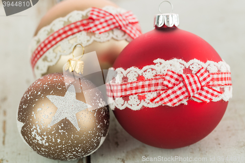 Image of Three Christmas baubles on rustic wood