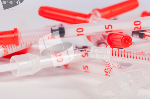 Image of Pile of Empty Syringes with Red Safety Caps