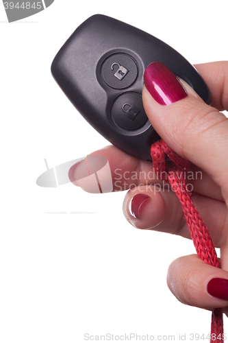 Image of Close up of hand holding car key on white