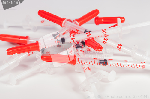 Image of Pile of Empty Syringes with Red Safety Caps