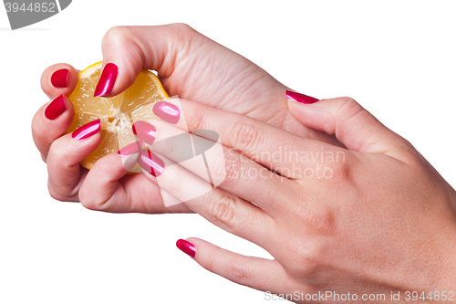 Image of Hand with manicured nails squeeze lemon on white