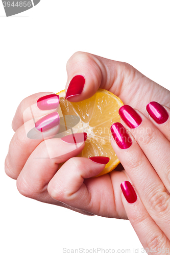 Image of Hand with manicured nails squeeze lemon on white