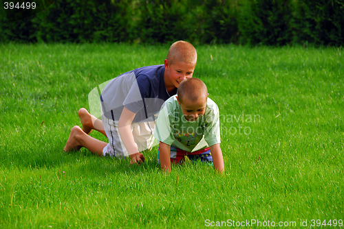 Image of two boys play on the grass