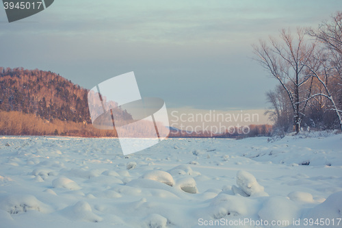 Image of winter landscape of snow-covered fields, trees 