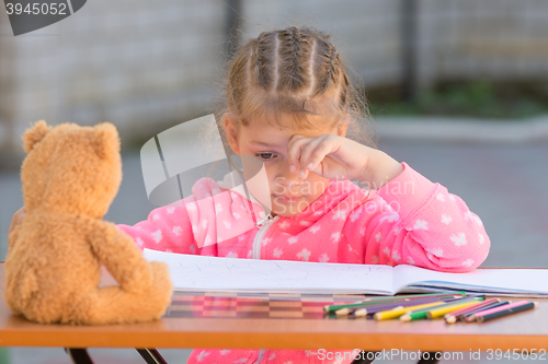 Image of The girl does not know how to continue to draw drawing pencils