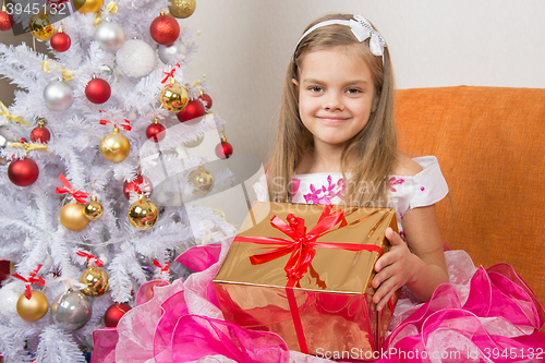 Image of girl in a beautiful dress gave New Year gift