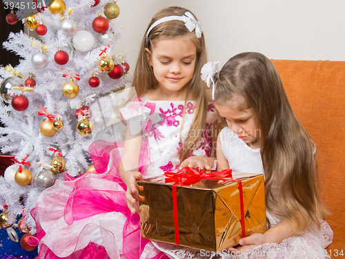 Image of The older girl gives younger unwanted gift