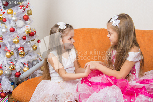 Image of Two girls in beautiful dresses waiting Gift joined hands