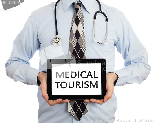 Image of Doctor holding tablet - Medical tourism