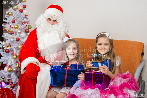 Image of Santa Claus gave presents to the children, and together looked in the frame