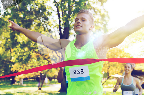 Image of happy young male runner winning on race finish