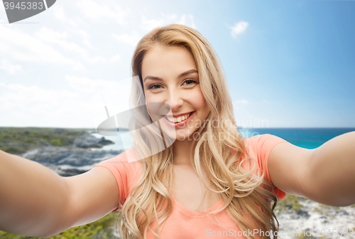 Image of happy smiling young woman taking selfie