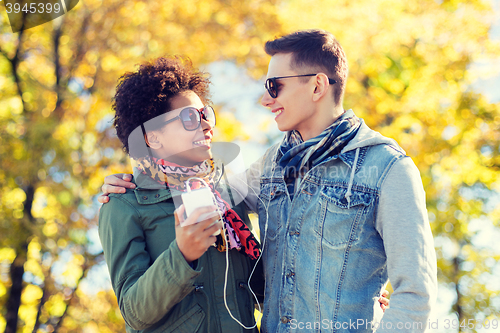 Image of smiling couple with smartphone and earphones