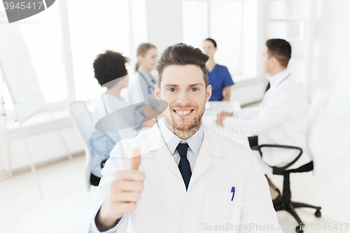 Image of happy doctor over group of medics at hospital