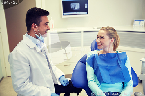 Image of happy male dentist with woman patient at clinic