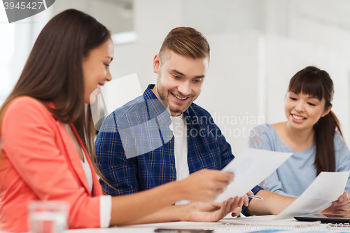 Image of happy creative team or students working at office