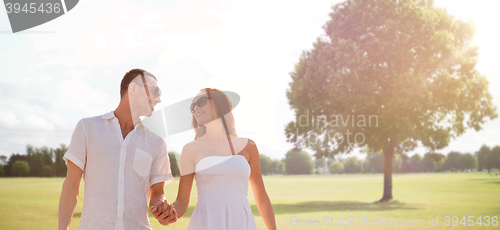 Image of happy smiling couple walking over summer park