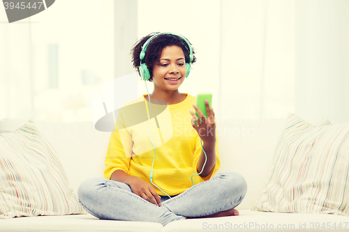 Image of happy african woman with smartphone and headphones