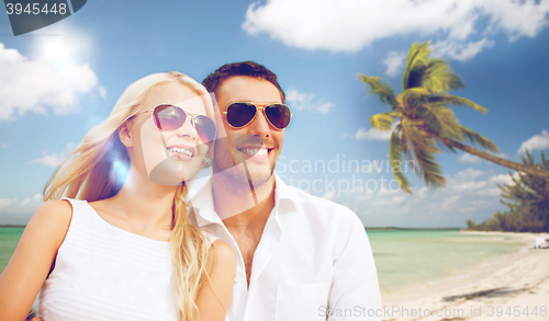 Image of happy couple in sunglasses at maldives beach