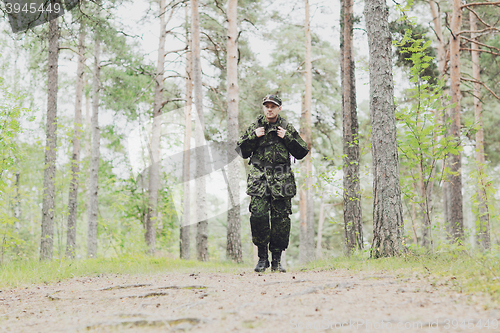 Image of young soldier with backpack in forest