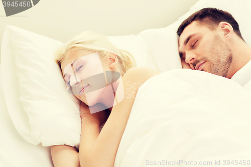 Image of happy couple sleeping in bed at home