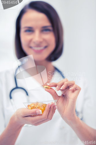 Image of doctor holding bowl of capsules