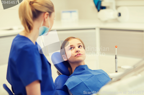 Image of happy female dentist with patient girl at clinic