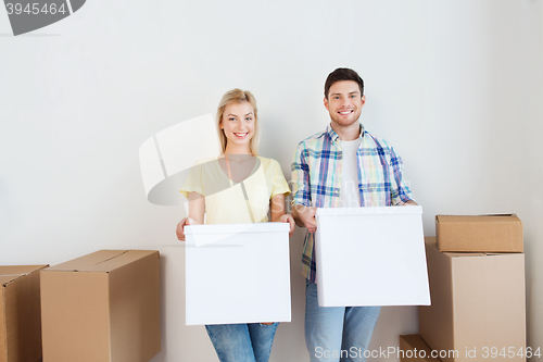 Image of smiling couple with big boxes moving to new home