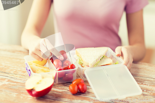 Image of close up of woman with food in plastic container