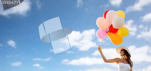 Image of smiling young woman in sunglasses with balloons