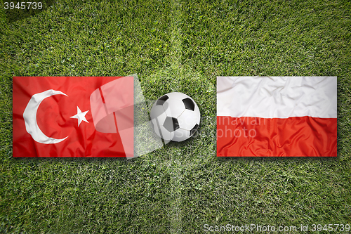 Image of Turkey vs. Poland flags on soccer field