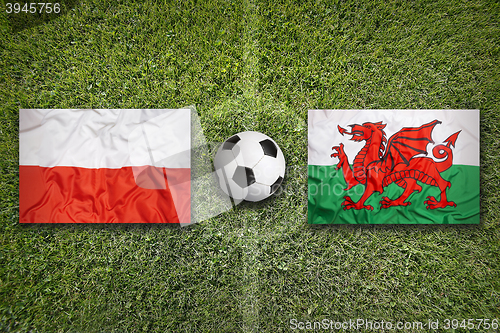 Image of Poland vs. Wales flags on soccer field