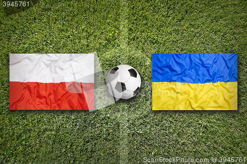 Image of Poland vs. Ukraine flags on soccer field