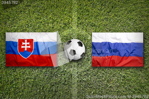 Image of Slovakia vs. Russia flags on soccer field