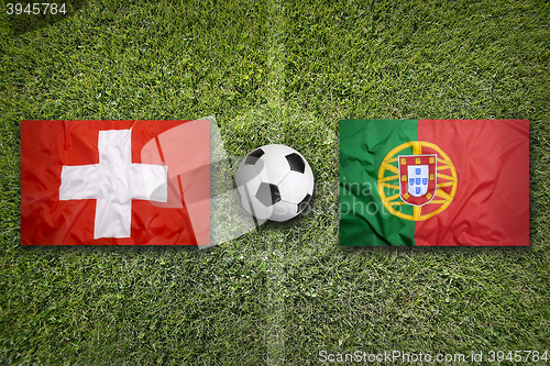 Image of Switzerland vs. Portugal flags on soccer field