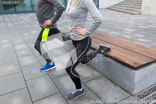 Image of close up of couple doing lunge exercise on street